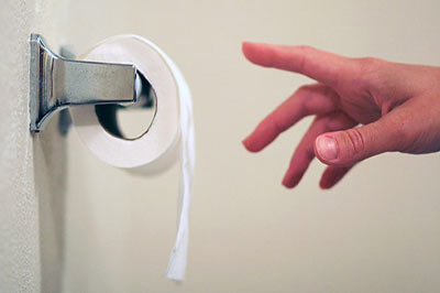 یک دست در حال گرفتن دستمال توالت سفید رنگ