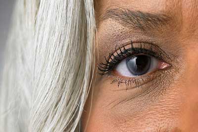 چشم راست یک زن با موهای سفید و پوست برنزه