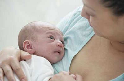 زنی با لباس آبی در حالیکه نوزادی را در آغوش گرفته و نوزاد به او نگاه می‌کند