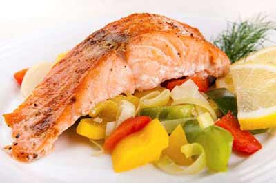 یک تکه ماهی سالمون بر روی سبزیجات