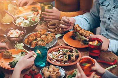میزی پر از خوراکیهای  گوناگون و لیوانهای رنگارنگ